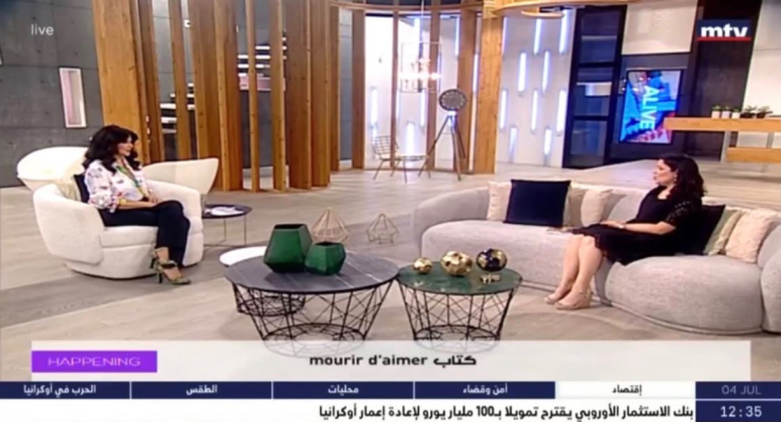 Plan plateau de l'émission Happening à MTV Lebanon — Salam Chaya à droite, la journaliste à gauche, bandeau « mourir d'aimer كتاب »